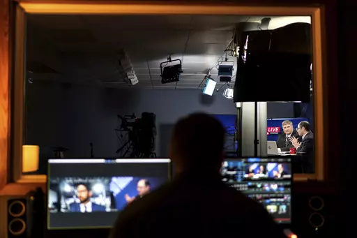 Executive Senior Editor Steve Bonta, left, and former writer Daniel Natal, with the John Birch Society's New American magazine, film a live broadcast at the organization's headquarters in Appleton, Wis., Thursday, Nov. 17, 2022. Back when the Cold War was looming and TV was still mostly in black and white, the Society was a powerful presence in American life. (AP Photo/David Goldman)