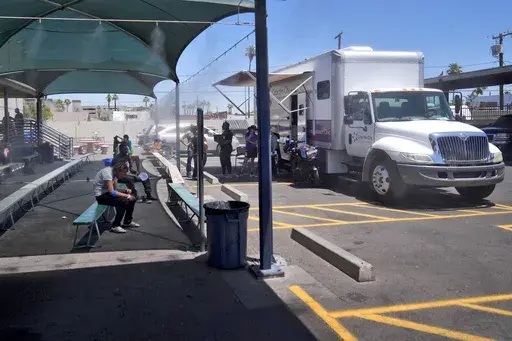 Patients gather outside one of the five Circle The City mobile clinics stationed outside a soup kitchen for homeless people, Thursday, May 30, 2024 in Phoenix. Based in the hottest big metro in America, Circle the City is taking measures to protect patients from life-threatening heat illness as temperatures hit new highs. Homeless people accounted for nearly half of the record 645 heat-related deaths last year in Arizona's Maricopa County, which encompasses metro Phoenix.(AP Photo/Matt York)