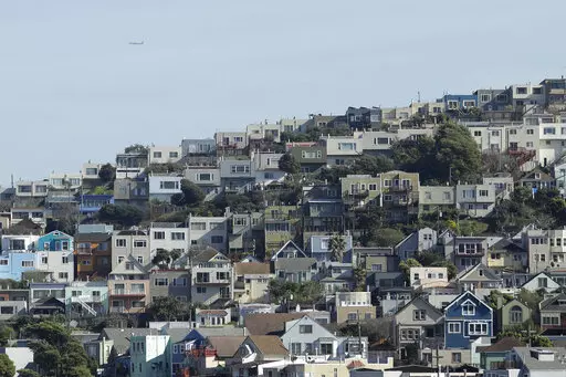 A plane flies over homes and residential buildings in San Francisco, Wednesday, March 4, 2020. California lawmakers have reached a deal on a pair of housing production bills. The bills would open up much of the state's commercial land for residential development. California has a housing shortage. (AP Photo/Jeff Chiu, File )
