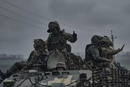 Ukrainian servicemen ride atop by an APC towards frontline positions near Vuhledar, Donetsk region, Ukraine, Monday, May 1, 2023. (AP Photo/Libkos)