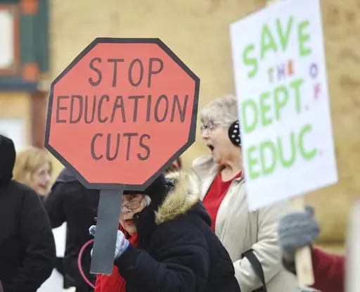 Dozens of people gather in downtown Niles, Mich., Thursday, March 20, 2025, to protest recent government cuts in the Department of Education. (Don Campbell/The Herald-Palladium via AP)