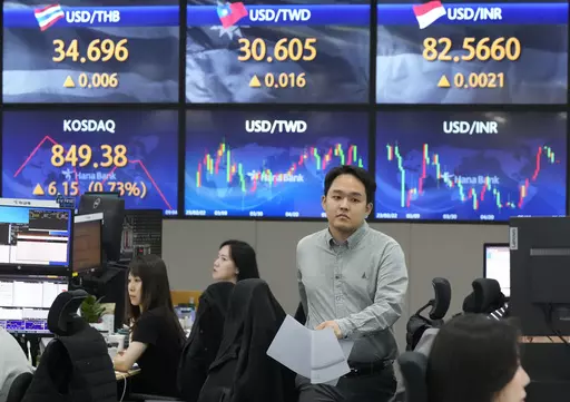 A currency trader passes by the screens showing the foreign exchange rates at the foreign exchange dealing room of the KEB Hana Bank headquarters in Seoul, South Korea, Tuesday, May 30, 2023. Asian shares were mixed in directionless trading Tuesday following a U.S. holiday, as optimism about a deal on the U.S. debt mixed with worries about the regional economy. (AP Photo/Ahn Young-joon)