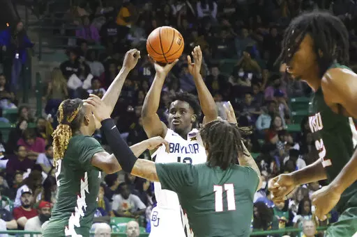 Baylor guard Adam Flagler scores over Mississippi Valley State guards Arecko Gipson, left, and Terry Collins (11) in the second half of an NCAA college basketball game, Monday, Nov. 7, 2022, in Waco, Texas. Baylor won 117-53. (AP Photo/Rod Aydelotte)