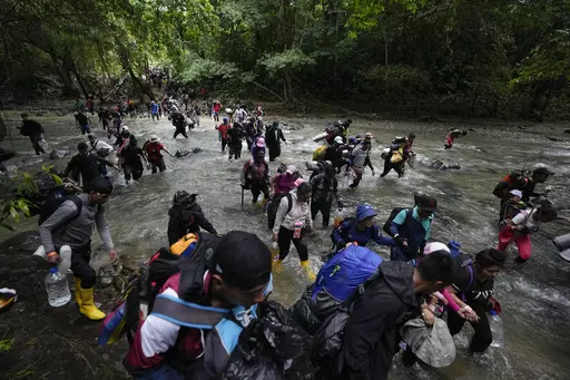 Migrants, mostly Venezuelans, cross a river during their journey through the Darien Gap from Colombia into Panama, hoping to reach the U.S., Oct. 15, 2022. The United States, Panama and Colombia announced Tuesday, April 11, 2023, that they will launch a 60-day campaign aimed at halting illegal migration through the treacherous Darien Gap, where the flow of migrants has multiplied this year. (AP Photo/Fernando Vergara, File)