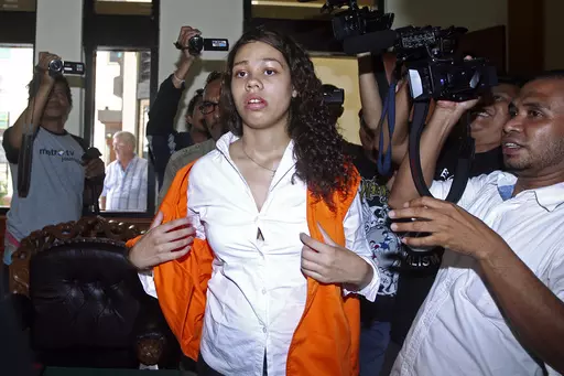 Heather Mack of Chicago, Ill., center, is mobbed by reporters as she arrives in the courtroom for her sentencing hearing at a district court in Denpasar, Bali, Indonesia, April 21, 2015. The Chicago woman facing federal conspiracy charges in the 2014 killing of her mother during a luxury vacation in Bali plans to plead guilty, her attorney said Thursday, June 1, 2023. (AP Photo/Firdia Lisnawati, File)