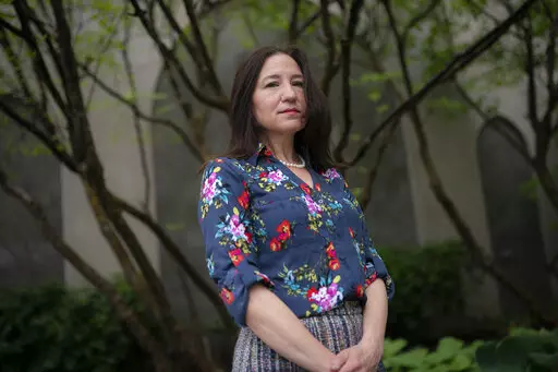 Allyson Jacobs stands for a portrait outside her workplace, Wednesday, May 4, 2022, in New York. For Jacobs, life in her 20s and 30s was about focusing on her career in health care and enjoying the club scene in New York City. It wasn't until she turned 40 that she and her husband started trying to have children. They had a son when she was 42.   (AP Photo/John Minchillo)