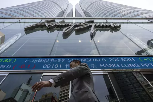 A pedestrian passes by the Hong Kong Stock Exchange electronic screen in Hong Kong, Wednesday, April 12, 2023. Asian shares were mostly higher Wednesday, as markets watched for key inflation data likely to influence the Federal Reserve's stance on interest rates. (AP Photo/Louise Delmotte)