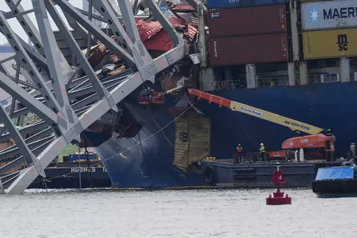 Workers remove wreckage of the collapsed Francis Scott Key Bridge, Thursday, April 25, 2024, in Baltimore. (AP Photo/Matt Rourke)