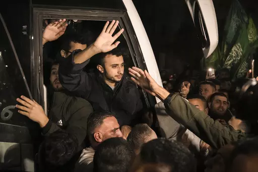 Men wave after being released from prison by Israel, Thursday, Nov. 30, 2023, in the West Bank town of Ramallah. (AP Photo/Nasser Nasser, File)