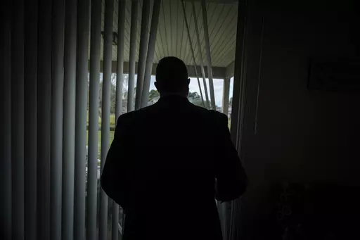 Joseph Moore looks out of a window at his home in Jacksonville, Fla., on Tuesday, Dec. 7, 2021. Moore worked for nearly 10 years as an undercover informant for the FBI, infiltrating the Ku Klux Klan in Florida, foiling at least two murder plots, according to investigators, and investigating ties between law enforcement and the white supremacist organization. "From where I sat, with the intelligence laid out, I can tell you that none of these agencies have any control over any of it. It is more p