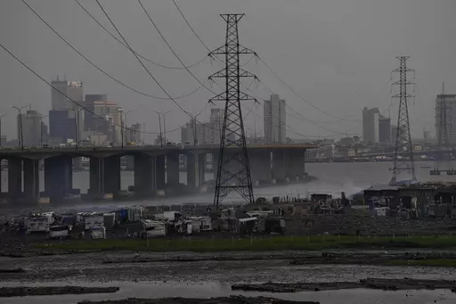 High tension power lines pass through Makoko slum in Lagos, Nigeria, Saturday, Aug. 20, 2022. From Zimbabwe, where many must work at night because i t's the only time there is power, to Nigeria where collapses of the grid are frequent, the reliable supply of electricity remains elusive across Africa. (AP Photo/Sunday Alamba/File)