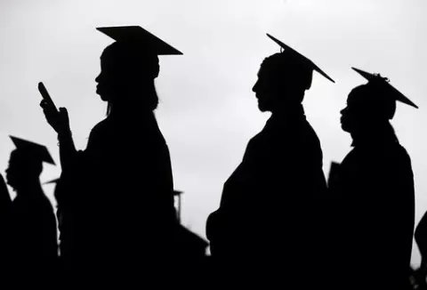 New graduates line up before the start of a community college commencement in East Rutherford, N.J., on May 17, 2018. President Joe Biden is expected to announce Wednesday Aug. 24, 2022 that many Americans can have up to $10,000 in federal student loan debt forgiven. (AP Photo/Seth Wenig, File)