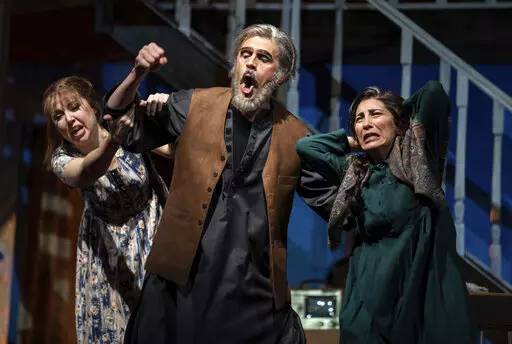 Maureen McKay, left, who portrays Laila, John Moore, who portrays Rasheed, and Karin Mushegain, who portrays Mariam, perform in a dress rehearsal for the opera "A Thousand Splendid Suns," in Seattle, on Wednesday, Feb. 22, 2023. Making its world debut Saturday, Feb. 25, 2023, it is based on a popular novel by Kabul-born author Khaled Hosseini that explores the inner worlds of Mariam and Laila over decades of Afghan history, some with stark parallels to the present. (AP Photo/Stephen Brashear)