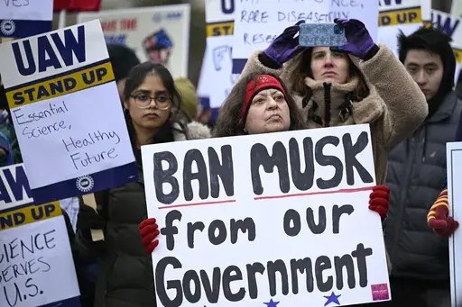 People rally at Health and Human Services headquarters to protest the polices of President Donald Trump and Elon Musk Wednesday, Feb. 19, 2025, in Washington. (AP Photo/John McDonnell)