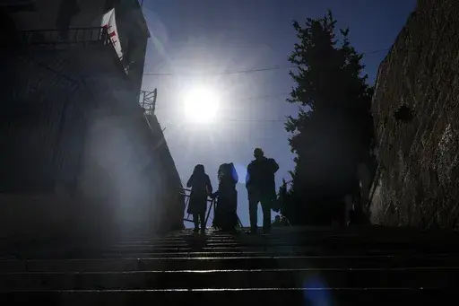 Worshippers walk down the stairs next to the Church of the Nativity, traditionally believed to be the birthplace of Jesus, in the West Bank city of Bethlehem, Wednesday, Dec. 25, 2024. (AP Photo/Matias Delacroix)