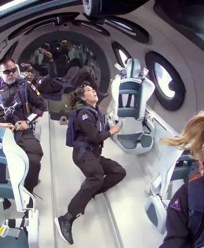 This photo released by Virgin Galactic shows mission specialist Jamila Gilbert, center, looking out one of the portal windows as she experiences weightlessness during a test flight on Thursday, May 25, 2023. Virgin Galactic completed what’s expected to be its final test flight Thursday before taking paying customers on brief trips to space. (Virgin Galactic via AP)