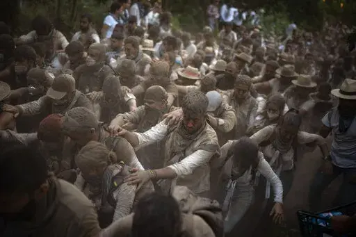 Pilgrims walk in the Donana National Park on their way to the shrine of El Rocio in Almonte, Spain, on Friday June 3, 2022, during the annual pilgrimage in which hundreds of thousands of devotees of the Virgin del Rocio converge in and around the shrine. After a two-year hiatus forced by the pandemic, tens of thousands of pilgrims – many of them outfitted in tiered flamenco dresses, crisp riding suits and wide-brimmed Cordoba hats – descended on the tiny Spanish village of El Rocío to take 