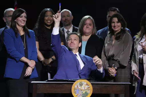Florida Gov. Ron DeSantis throws a marker into the audience after signing various bills during a bill signing ceremony at the Coastal Community Church at Lighthouse Point, Tuesday, May 16, 2023, in Lighthouse Point, Fla. (AP Photo/Wilfredo Lee)