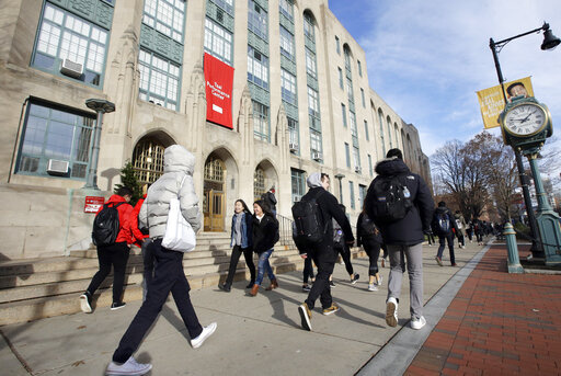 In this Thursday, Nov. 29, 2018, photo students and passers-by walk past an entrance to Boston University College of Arts and Sciences in Boston.  Everyone can’t be a STEM major; there are still vital roles necessary in lower-paying fields like humanities, arts and social sciences. But when you follow your dreams from college to career, the return doesn’t always match the investment — especially if you take on debt.  (AP Photo/Steven Senne, File)