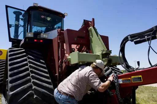 Farmer Nathan Weathers configures a high-power, high-tech quad-track tractor near his farm in Yuma, Colo, June 30, 2008. Lawmakers in Colorado and 10 other states have introduced bills that would force farming equipment manufacturers to provide the tools, software, parts and manuals needed for farmers to do their own repairs. The bills are a response to farmers unable to repair their own tractors and combines, forcing them to wait sometimes days and paying steep labor costs. (Brian Brainerd/The 