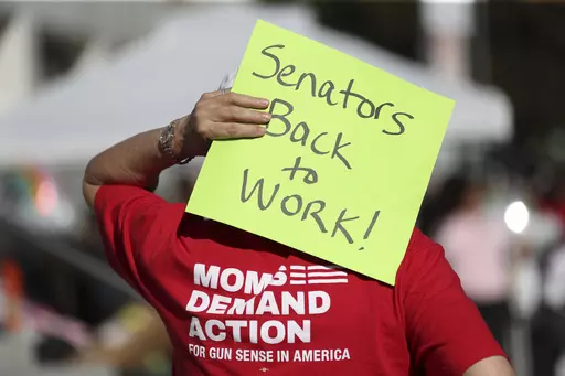 An attendee holds a sign behind their head during a rally calling for an end to the Senate Republican walkout at the Oregon State Capitol in Salem, Ore., May 11, 2023. Republicans and an independent senator in the Oregon Senate stretched a walkout Monday, May 15, to 10 days, triggering a new constitutional provision that prohibits lawmakers with 10 or more unexcused absences from being reelected. The walkout that began May 3 has stalled action on hundreds of bills, including on gun control, gend