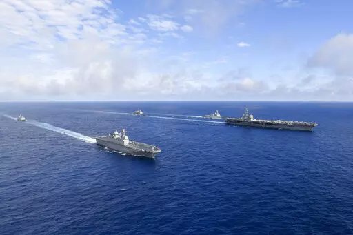 In this photo provided by South Korea's Defense Ministry, U.S. nuclear-powered aircraft carrier USS Ronald Reagan, right, and South Korea's landing platform helicopter (LPH) ship Marado, second from left, sail during a joint military exercise at an undisclosed location, Saturday, June 4, 2022. (South Korea Defense Ministry via AP)