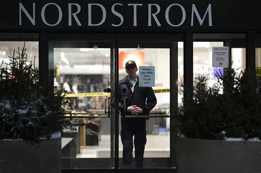An officer stands inside Nordstrom at Mall of America after a shooting, Friday, Dec. 23, 2022, in Bloomington, Minn. A suspect wanted in connection with the fatal shooting at the mall in December was arrested in Georgia on Tuesday, Jan. 17, 2023. (AP Photo/Abbie Parr)