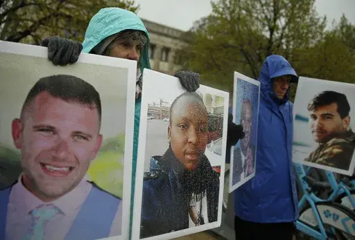 Protesters hold photographs of victims, including Melvin Riffel, left, of the 2019 Ethiopian Airlines plane crash, outside Boeing's annual shareholders meeting in Chicago on April 29, 2019. Ike Riffel, a California father whose two sons, Melvin and Bennett, died in the crash, fears that instead of putting Boeing on trial, the government will offer the company another shot at corporate probation through a legal document called a deferred prosecution agreement, or DPA. (AP Photo/Jim Young, File)