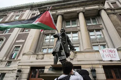 A student protester parades a Palestinian flag outside the entrance to Hamilton Hall on the campus of Columbia University, Tuesday, April 30, 2024, in New York. The student-run legal journal, Columbia Law Review, was taken offline Monday, June 3, 2024, after its board of directors objected to the publication of an article that accused Israel of genocide. (AP Photo/Mary Altaffer, Pool, File)