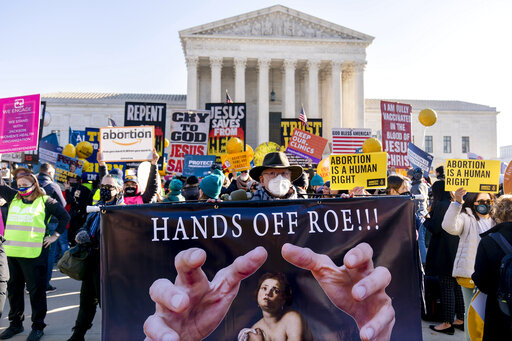 Stephen Parlato of Boulder, Colo., holds a sign that reads "Hands Off Roe!!!" as abortion rights advocates and anti-abortion protesters demonstrate in front of the U.S. Supreme Court, Dec. 1, 2021, in Washington, as the court hears arguments in a case from Mississippi, where a 2018 law would ban abortions after 15 weeks of pregnancy, well before viability. Abortion funds, entities that raise money to aid women get abortions, say they would need more donations this year if the U.S. Supreme Court 