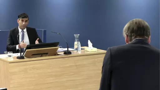 This screen grab from the UK COVID-19 Inquiry live stream shows Britain's Prime Minister Rishi Sunak giving evidence at Dorland House, in London, Monday, Dec. 11, 2023. Sunak faces one of the toughest weeks of his 13 months in office. On Monday he will be grilled by lawyers about his decisions during the COVID-19 pandemic while fending off a rebellion from lawmakers over his signature immigration policy. (UK COVID-19 Inquiry/PA via AP)