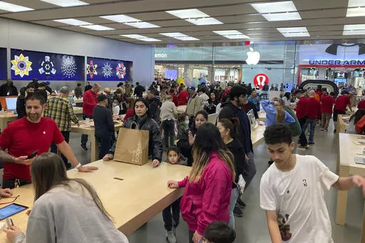 People shop at an Apple store in the Westfield Garden State Plaza mall in Paramus, New Jersey, on Saturday, December 17, 2022. On Friday, the Commerce Department issues its February report on consumer spending. (AP Photo/Ted Shaffrey, File)