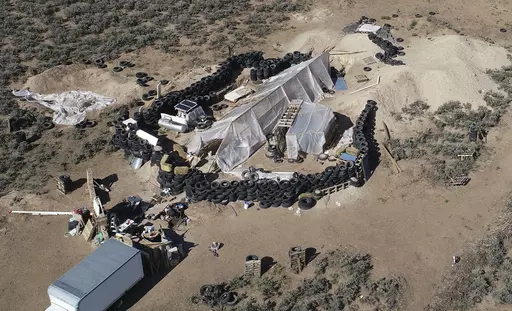 A ramshackle compound is seen in the desert area of Amalia, N.M., on Aug. 10, 2018. Two firearms charges were dismissed Thursday, Sept. 21, 2023, amid preparations for trial against an extended family arrested in a 2018 law enforcement raid on the compound in northern New Mexico and the discovery of a young boy's decomposed body. (AP Photo/Brian Skoloff, File)