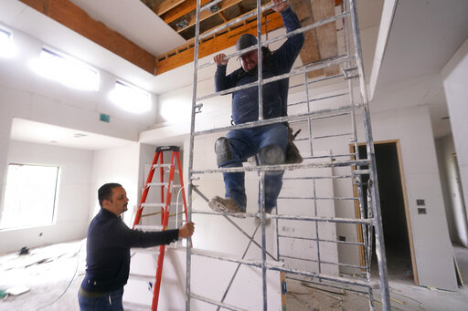 Joshua Correa, left, steadies a scaffolding for Samuel as they work at a home under construction in Plano, Texas, Tuesday, May 3, 2022. There are an estimated 2 million fewer immigrants than expected in the United States, helping fuel a desperate scramble for workers in many sectors, from meatpacking to homebuilding, that are also contributing to shortages and price increases. Correa has struggled to hire supervisors for his work sites, with immigrant job candidates demanding $100,000 yearly pay