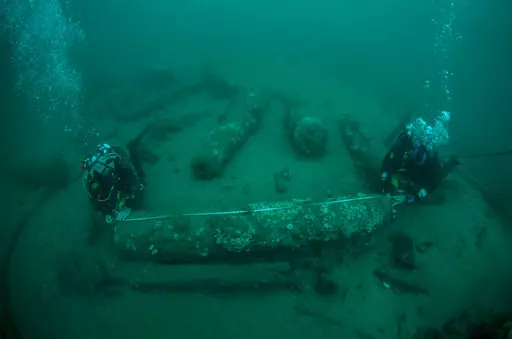 In this undated photo provided by Norfolk Historic Shipwrecks, Julian And Lincoln Barnwell measure the cannon found on the HMS Gloucester in 2007. Excavators and historians are telling the world about the wreck of a royal warship that sank in 1682 while carrying the future king James Stuart. The HMS Gloucester ran aground while navigating sandbanks off the town of Great Yarmouth on the eastern English coast. The wreck of the Gloucester was found in 2007 by brothers Julian and Lincoln Barnwell an