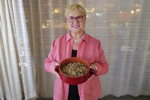 This image released by PBS shows celebrity chef Lidia Bastianich holding her recipe for escarole and white bean soup in Washington, DC on Nov. 7, 2022. The Emmy-award winning TV host, author and restaurateur explores the immigrant experience through food in the PBS special "Lidia Celebrates America: Flavors That Define Us.” (Meredith Nierman/PBS via AP)