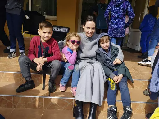 In this image provided by the Lviv city hall Angelina Jolie, Hollywood movie star and UNHCR goodwill ambassador, poses for photo with kids in Lviv, Ukraine, Saturday, Apr. 30, 2022. Ms Jolie was in Ukraine to meet the children affected by the war and visited hospitals and NGOs helping the injured and displaced. (Maksym Kozutsky/Lviv City Hall via AP)