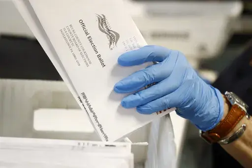 A worker processes mail-in ballots at the Bucks County Board of Elections office prior to the primary election in Doylestown, Pa., May 27, 2020. (AP Photo/Matt Slocum, File)