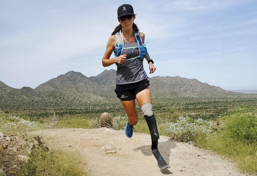 In this image provided by Edwin Broersma, marathoner Jacky Hunt-Broersma trains on Aug. 28, 2021 at San Tan Mountain Regional Park, in San Tan Valley, Az. Hunt-Broersma lost her left leg below the knee to a rare form of cancer, but she hasn't let that stop her and is trying to cover the classic 26.2-mile marathon distance at least 102 times in 102 days, which would set a new world record. The Boston Marathon on April 18 is expected to be No. 92 in her streak. (Edwin Broersma via AP)