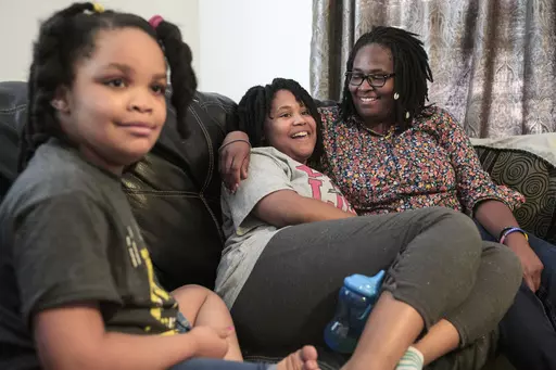 Deleah Payne, 12, center, spends time with her mother Delisa, right, and 6-year-old sister Delynn, left, as they watch movie clips on their living room television in Evansville, Ind., Tuesday evening, Aug. 27, 2019. Deleah and Delynn were both diagnosed with autism. For the first time, autism is being diagnosed more frequently in Black and Hispanic children than in white kids in the U.S., the Centers for Disease Control and Prevention said Thursday, March 23, 2023. (Sam Owens/Evansville Courier 