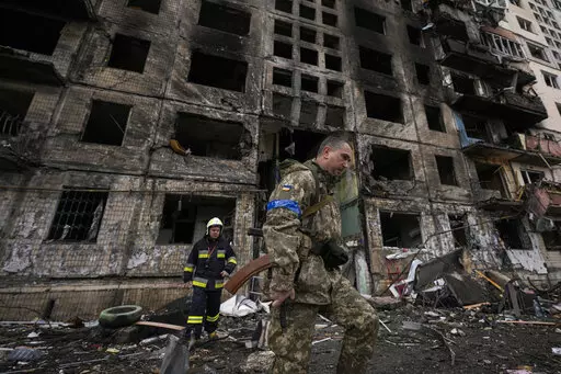 Ukrainian soldiers and firefighters search in a destroyed building after a bombing attack in Kyiv, Ukraine, Monday, March 14, 2022. (AP Photo/Vadim Ghirda, File)