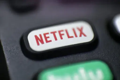 A logo for Netflix is seen on a remote control in Portland, Ore., on Aug. 13, 2020. Netflix will unveil the first version of its video streaming service with ads in November 2022, giving cost-conscious viewers a chance to watch most of its shows at a steep discount in exchange for putting up with commercial interruptions. (AP Photo/Jenny Kane, File)