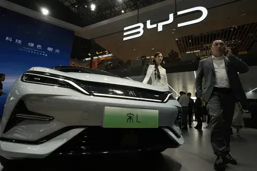 A model poses near the BYD Song L EV car during Auto China 2024 held in Beijing, April 25, 2024. (AP Photo/Ng Han Guan, File)