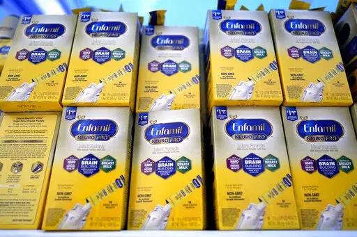 Infant formula is stacked on a table during a baby formula drive to help with the shortage May 14, 2022, in Houston.  President Joe Biden has invoked the Defense Production Act to speed production of infant formula and has authorized flights to import supply from overseas. (AP Photo/David J. Phillip, File)
