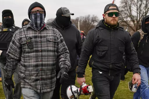 FILE - Proud Boys members Joseph Biggs, left, and Ethan Nordean, right with megaphone, walk toward the U.S. Capitol in Washington, Jan. 6, 2021. A federal judge on Tuesday, Dec. 28 refused to dismiss an indictment charging four alleged leaders of the far-right Proud Boys, Ethan Nordean, Joseph Biggs, Zachary Rehl and Charles Donohoe, with conspiring to attack the U.S. Capitol to stop Congress from certifying President Joe Biden's electoral victory. (AP Photo/Carolyn Kaster, File)