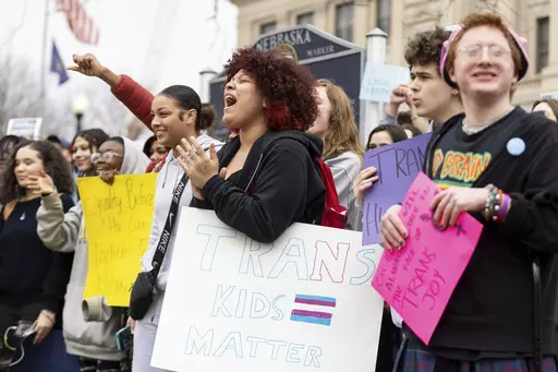 Mae Keller, a senior, carries a "Trans Kids Matter" sign and cheers as hundreds of students walk out of school on Transgender Day of Visibility outside Omaha Central High School on March 31, 2023, in Omaha, Neb. Republican-controlled states across the U.S. are imposing restrictions aimed at transgender students. (Anna Reed/Omaha World-Herald via AP, File)