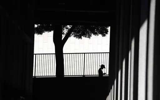 A person is silhouetted against a wall as they look down at their cell phone outside the Clara Shortridge Foltz Criminal Justice Center on July 29, 2021, in Los Angeles. With abortion now or soon to be illegal in over a dozen states and severely restricted in many more, Big Tech companies that vacuum up personal details of their users are facing new calls to limit that tracking and surveillance. One fear is that law enforcement or vigilantes could use those data troves against people seeking way