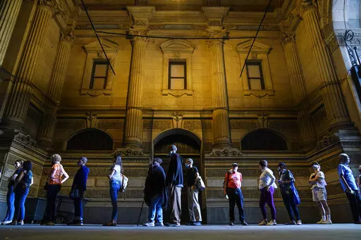 Voters wait in line to make corrections to their ballots for the midterm elections at City Hall in Philadelphia, Monday, Nov. 7, 2022. According to data from AP VoteCast, voters with no religious affiliation supported Democratic candidates and abortion rights by staggering percentages in the 2022 midterm elections. (AP Photo/Matt Rourke)