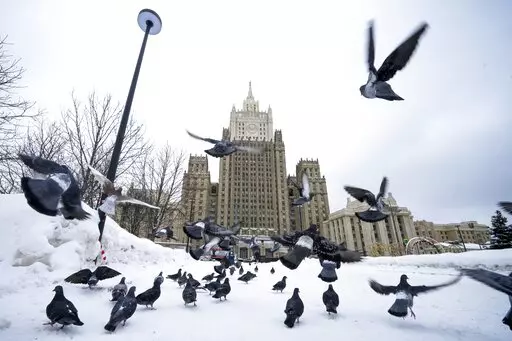 Pigeons take off in front of the Russian Foreign Ministry building in Moscow, Russia, Wednesday, Jan. 26, 2022. Russian Foreign Minister Sergey Lavrov said he and other top officials will advise President Vladimir Putin on the next steps after receiving written replies from the United States to the demands. Those answers are expected this week — even though the U.S. and its allies have already made clear they will reject the top Russian demands. (AP Photo/Alexander Zemlianichenko)