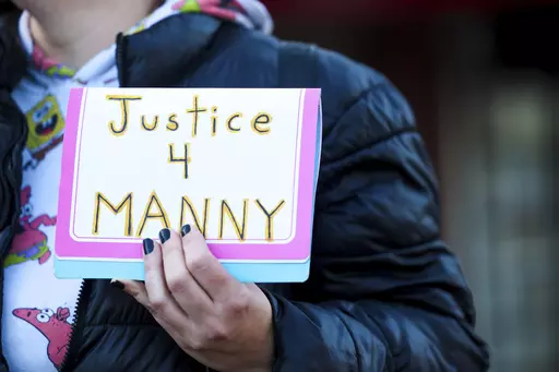 A protester holds a sign during a rally after the verdict was read during the trial of three Tacoma Police officers in the death of Manny Ellis, at Pierce County Superior Court, Thursday, Dec. 21, 2023, in Tacoma, Wash. A jury cleared the three police officers of all criminal charges. (AP Photo/Maddy Grassy)